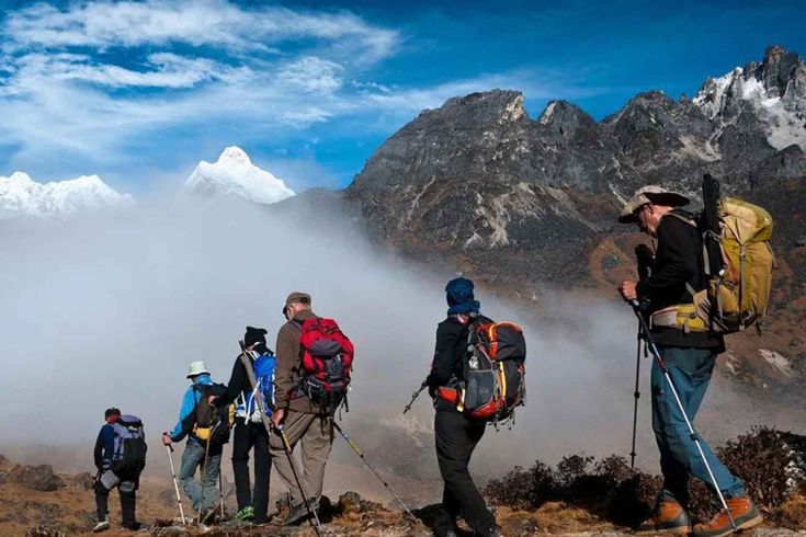 Trekkers hiking in high altitude Himalayan mountains with snow peaks and clouds acute mountain sickness nepal