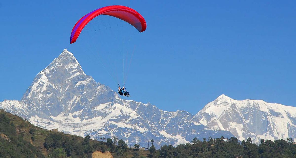 Paragliding Adventure Nepal | Trailblazers Nepal travelers doing paragliding in pokhara with beautiful view of machapuchhre mountain